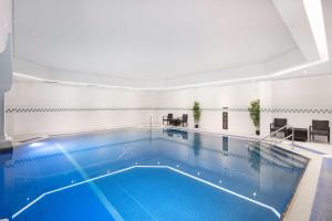 a large swimming pool in a building at DoubleTree By Hilton Brighton Metropole in Brighton & Hove