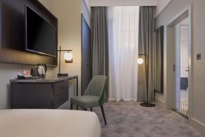 a hotel room with a desk and a chair at DoubleTree By Hilton Brighton Metropole in Brighton & Hove