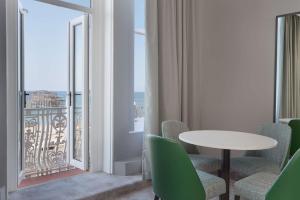 a room with a table and chairs and a balcony at DoubleTree By Hilton Brighton Metropole in Brighton & Hove