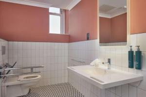 a bathroom with a sink and a toilet at DoubleTree By Hilton Brighton Metropole in Brighton & Hove