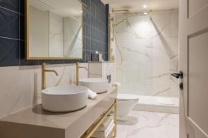 a bathroom with two sinks and a toilet and a tub at DoubleTree By Hilton Brighton Metropole in Brighton & Hove