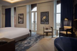 a hotel room with a bed and a desk and chairs at DoubleTree By Hilton Brighton Metropole in Brighton & Hove