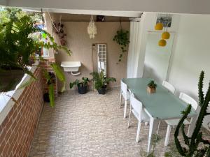 un patio con mesa, sillas y plantas en Casa Zona Sul, en Río de Janeiro