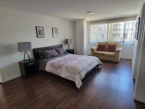 - une chambre avec un grand lit et un canapé dans l'établissement Lujoso apartamento en Bellavista, à Quito