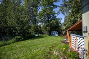 a backyard with a yard with a fence at The Mint Cottage with Garden in Anchorage