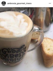 a cup of coffee and some bread on a table at Hotel Ambrosia Lodge in Rivera