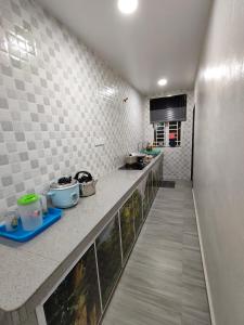a kitchen with a long counter in a room at Homestay Melaka Baitul Saadah in Melaka