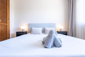 een slaapkamer met een wit bed en handdoeken bij Top floor spacious apartment with sea views in Costalita in Estepona