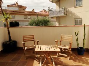 two chairs and a wooden table on a patio at Antonio's Apartment in Sitges
