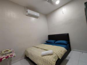 um pequeno quarto com uma cama e ar condicionado em Homestay Melaka Baitul Saadah em Malaca