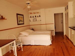 1 dormitorio con cama blanca y mesa en Antonio's Apartment, en Sitges