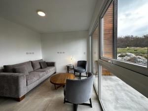 a living room with a couch and a table and a window at Starigrad in Ushuaia