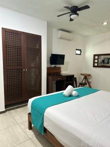 1 dormitorio con 1 cama y TV de pantalla plana en Casa TICUL Hotel Boutique - 5Th Ave, en Playa del Carmen