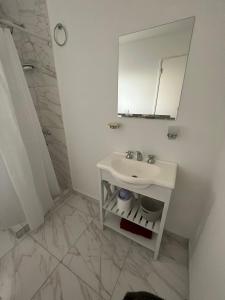 a white bathroom with a sink and a mirror at Departamento nuevo con balcón in Olavarría +11 photos