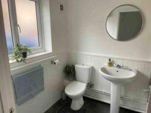 a bathroom with a toilet and a sink and a mirror at Stylish Property in Nuneaton in Nuneaton