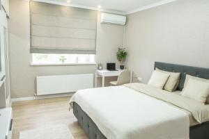 a bedroom with a bed and a desk and a window at Spacious Living- Free Coffee, Netflix & More! in Chişinău