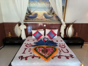 a bed with a heart made out of flowers at Baruna Sari Villa view jungle in Ubud