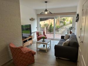 a living room with a couch and chairs and a tv at CASA VILLACERRADA in Navacerrada