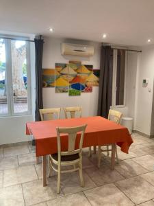 Appartement «Marrakech » à Avignon في أفينيون: غرفة طعام مع طاولة حمراء وكراسي