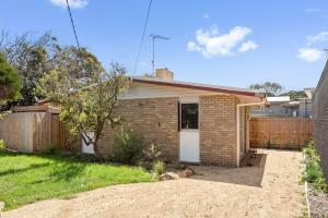 una casa de ladrillo con una valla en un patio en Surfside, en Point Lonsdale 5 fotos más