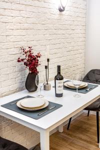 a white table with two plates and a bottle of wine at Spacious Living- Free Coffee, Netflix & More! in Chişinău
