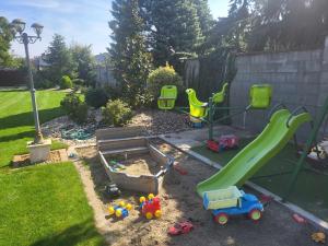 a playground with a slide and toys in a yard at Sika Palladium Central Apartment in Arad