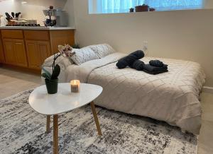ein Wohnzimmer mit einem Bett und einem Tisch in der Unterkunft 9AM Check-in Coastal Getaway - Luxe Suite near Cliff, Lake & Local Shops in Daly City
