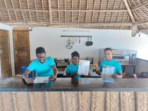 grupa mężczyzn stojących wokół stołu w obiekcie Ocean View Villa with pool, Zanzibar w mieście Pingwe