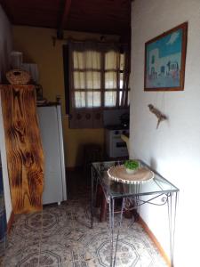 a kitchen with a glass table and a refrigerator at Lo de Fabi in La Coronilla