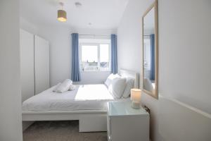 a white bedroom with a bed and a mirror at Entire 1 Bed - No. 45 - Free Parking - The Cosy Collection Ltd in York