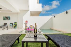 uma mesa com dois copos e uma garrafa de vinho em Cenote Korima - Relax in Paradise - Stunning House with Pool em Cancún