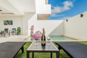 a table with two glasses and a bottle of wine at Cenote Korima - Relax in Paradise - Stunning House with Pool in Cancún