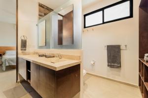 a bathroom with a sink and a mirror at Aquí y Ahora Bed & Breakfast Peaceful Shared Home with Pool in Cancún +26 photos