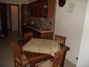 uma cozinha com mesa e cadeiras e um relógio na parede em Il Glicine em Capo dʼOrlando