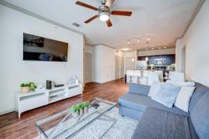uma sala de estar com um sofá azul e uma ventoinha de tecto em Stylish 2BR/2BA Apt Near NRG, Gym, Pool, Pets Ok. em Houston