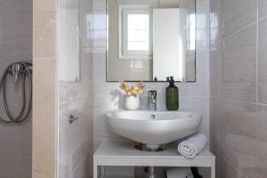 a white bathroom with a sink and a mirror at Estudio Frankie in L'Escala