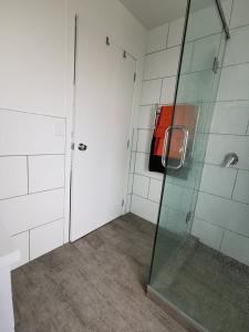 a bathroom with a shower and a glass door at MAGNOLIA HOUSE in Featherston