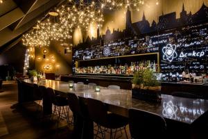 eine Bar mit einem langen Tisch, Stühlen und Lampen in der Unterkunft Motel One Ulm in Ulm