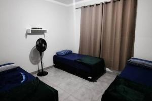 Pokój z 2 łóżkami, wentylatorem i zasłonami w obiekcie North Park 388 w mieście Campo Grande