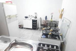 kuchnia z kuchenką z garnkami i patelniami w obiekcie North Park 388 w mieście Campo Grande