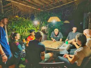 un groupe de personnes assises autour d'une table jouant à un jeu dans l'établissement Simba Guest house, à Sigirîya