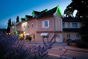 ヴィルフランシュ・ド・ルエルグにあるLe Relais de Farrouの緑の屋根の大ピンクの建物