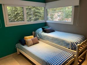 2 Betten in einem Zimmer mit 2 Fenstern in der Unterkunft Losgumitas 2 in Mar de las Pampas