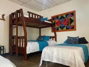 a bedroom with two beds and a bunk bed at LA ESTIBA HOTEL in Salento
