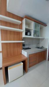 a small kitchen with wooden cabinets and a sink at Studio at Galeri Ciumbuleuit Apartment 2 in Bandung