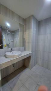 ein Bad mit einem Waschbecken und einem Spiegel in der Unterkunft Studio at Galeri Ciumbuleuit Apartment 2 in Bandung