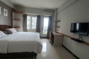 Schlafzimmer mit einem Bett und einem Flachbild-TV in der Unterkunft Studio at Galeri Ciumbuleuit Apartment 2 in Bandung