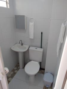 a white bathroom with a toilet and a sink at Vi&Li Suites in Aracaju