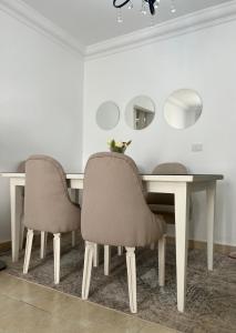 einen Esstisch mit 2 Stühlen und Spiegeln in der Unterkunft Grand Madinaty Couzy Home in Madinaty