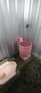 uma casa de banho com um WC cor-de-rosa e um lavatório. em Mangosteen Garden Inn em Bonjeruk